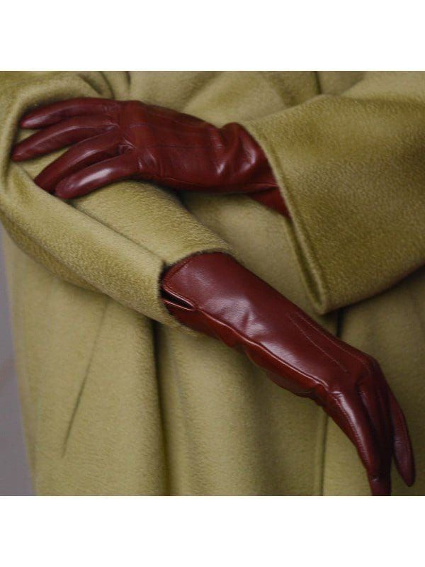 A close-up of burgundy gloves against a textured coat.